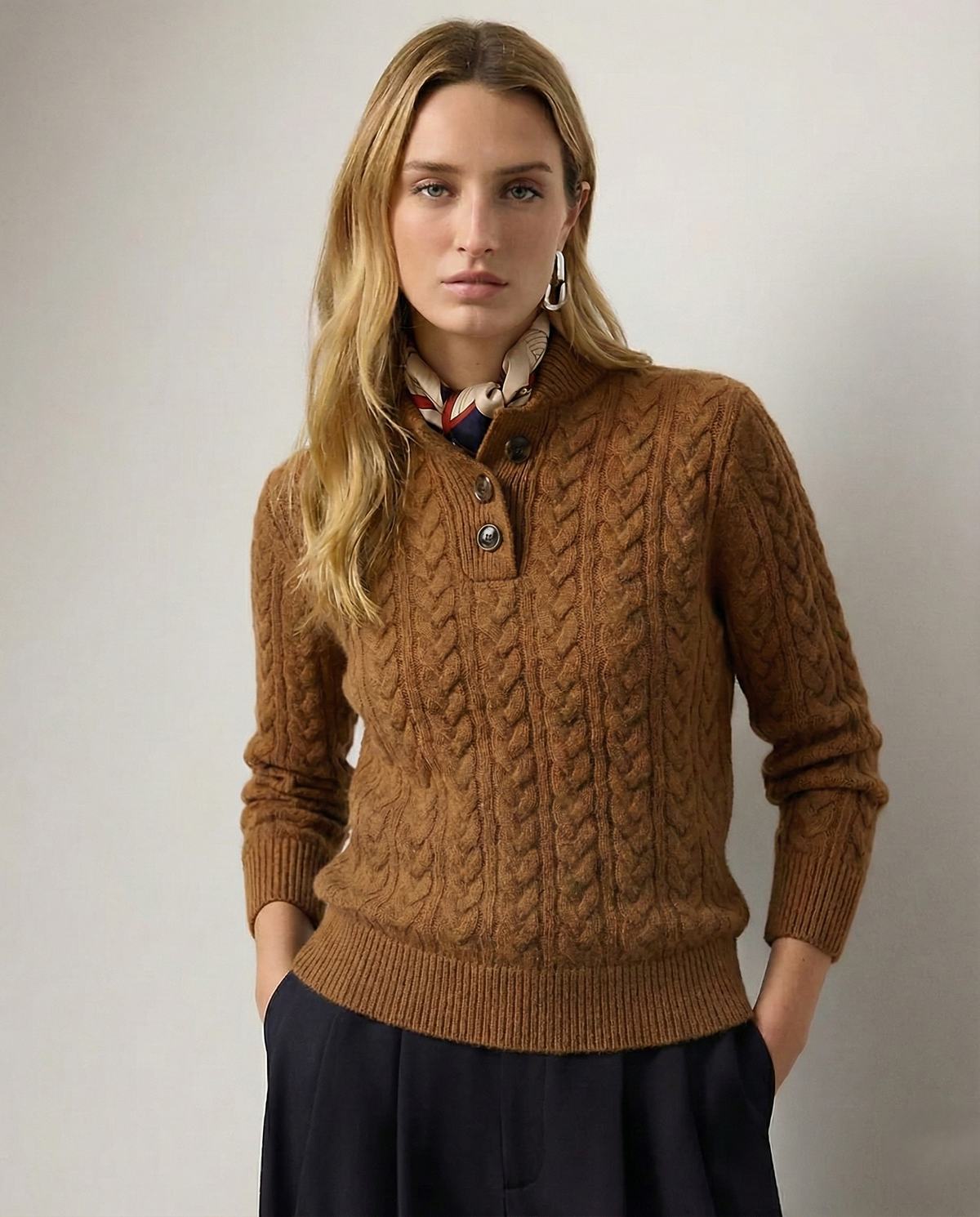Model wearing a brown cable knit button collar sweater with long sleeves and ribbed trims.