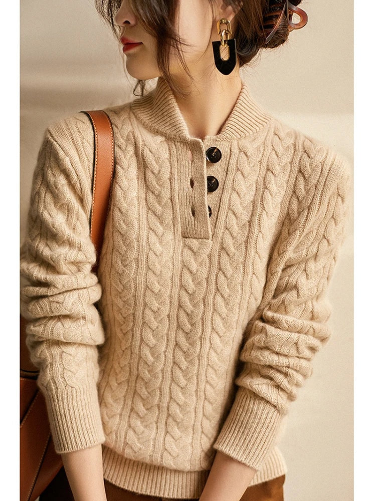Close upper-body view of the beige sweater showing its button placket, stand collar, and long ribbed sleeves.