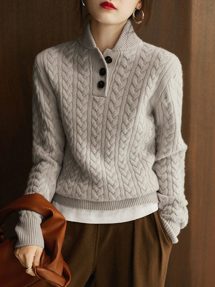 Front view of the light gray cable knit sweater showing its close-fitting shape and buttoned stand collar.