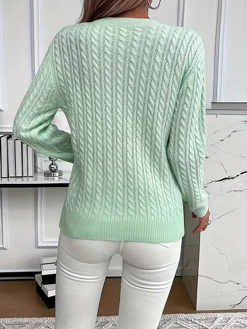 Back view of the mint green cable knit sweater, highlighting the vertical cable texture, ribbed hem, and long sleeves.