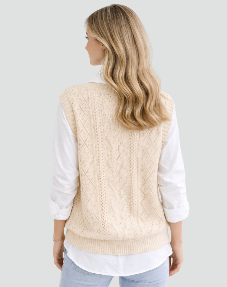 Back view of the cream sweater vest, showing the full cable knit pattern, relaxed shape, and defined ribbed hem.