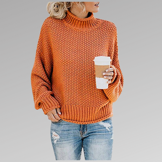 Chunky orange knit turtleneck sweater with long sleeves, ribbed cuffs and hip-length hem, styled with distressed jeans.