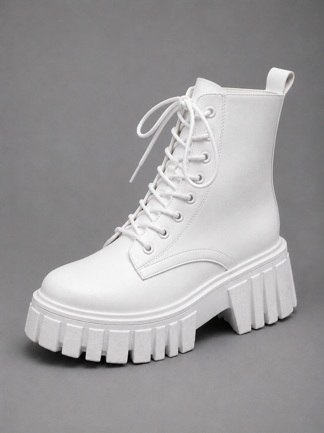 White ankle-height lace-up combat boot shown from a front three-quarter angle with a rounded toe and chunky platform outsole.