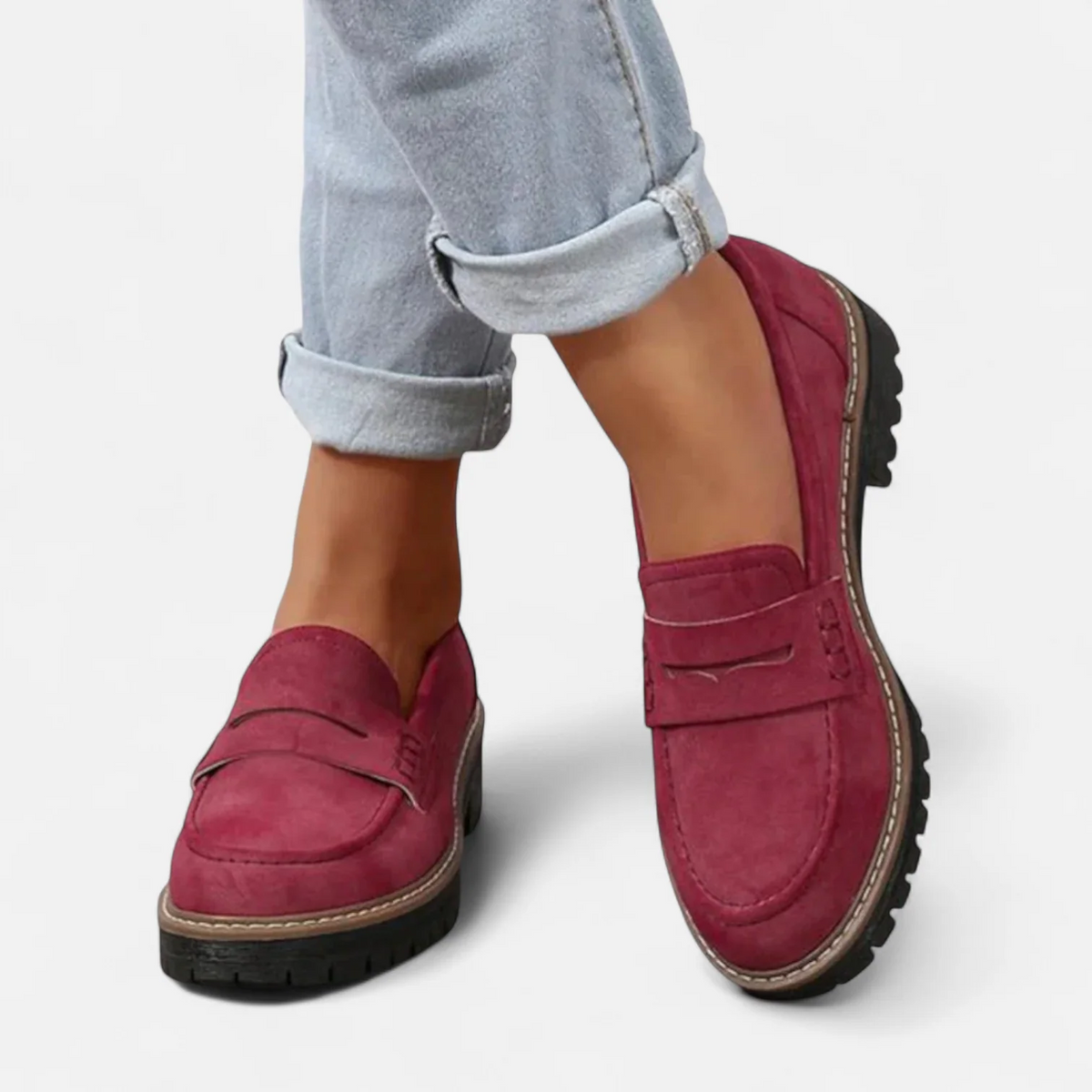 Burgundy penny loafers paired with cuffed jeans, including a side view that highlights the raised heel and textured outsole.