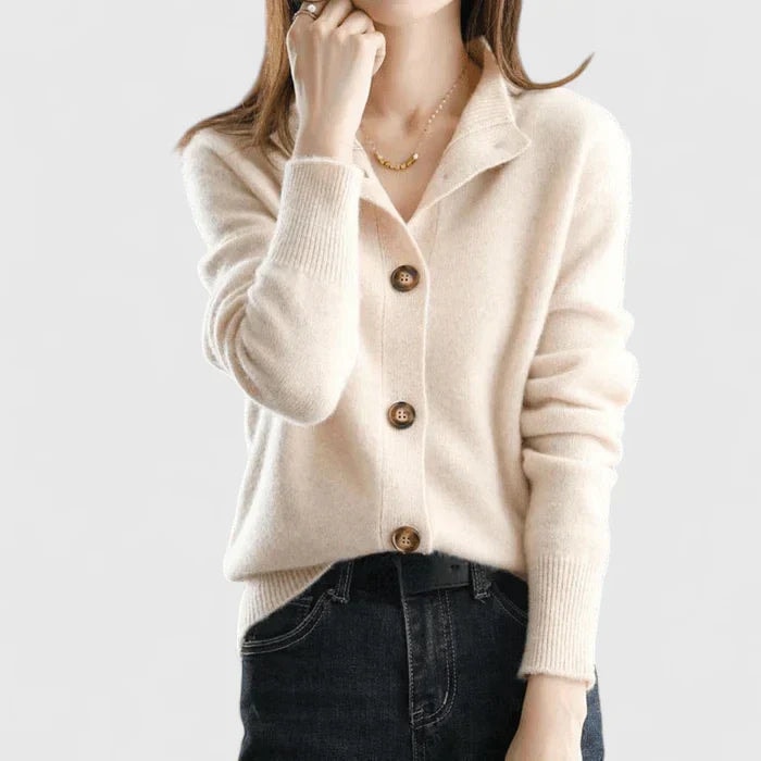 Cream collared button-front cardigan styled with dark jeans, showing its long sleeves, ribbed cuffs, and regular-length fit.