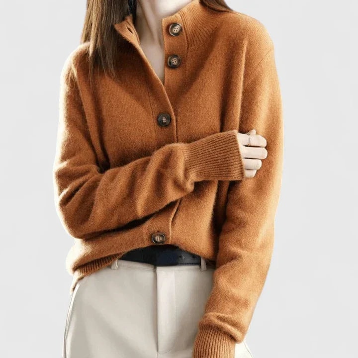 Caramel collared cardigan worn with light trousers, featuring a button-front closure and sleeves gathered slightly at the cuffs.