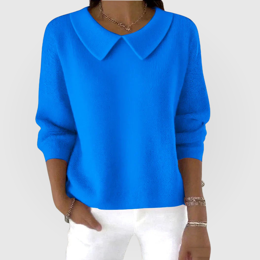 Bright blue collared sweater with a relaxed silhouette, long sleeves, and fitted cuffs, shown with white trousers.
