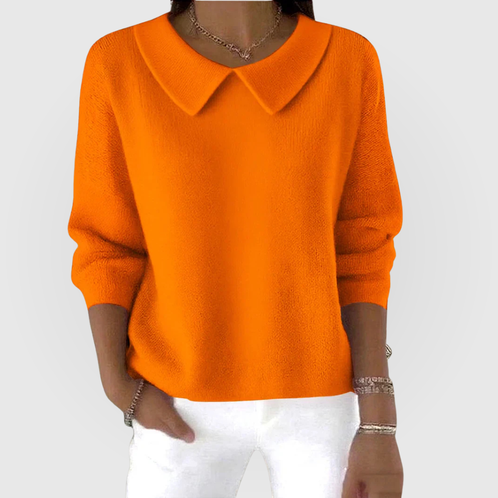 Orange relaxed-fit sweater with a defined pointed collar, long sleeves, and neat fitted cuffs, paired with white trousers.