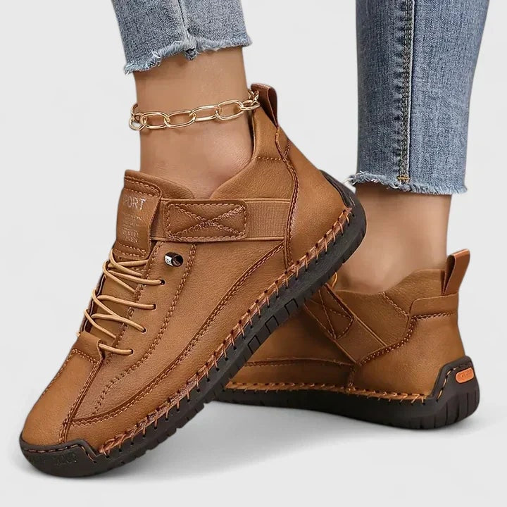 Brown sneakers with black outsoles, contrasting stitching, lace-up fronts, and adjustable ankle straps.