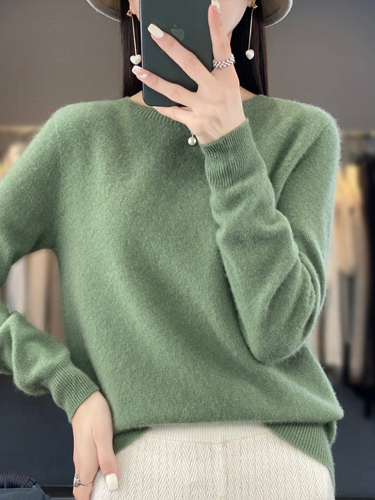 Sage green crew neck sweater with long sleeves and ribbed cuffs, styled with a light patterned bottom.
