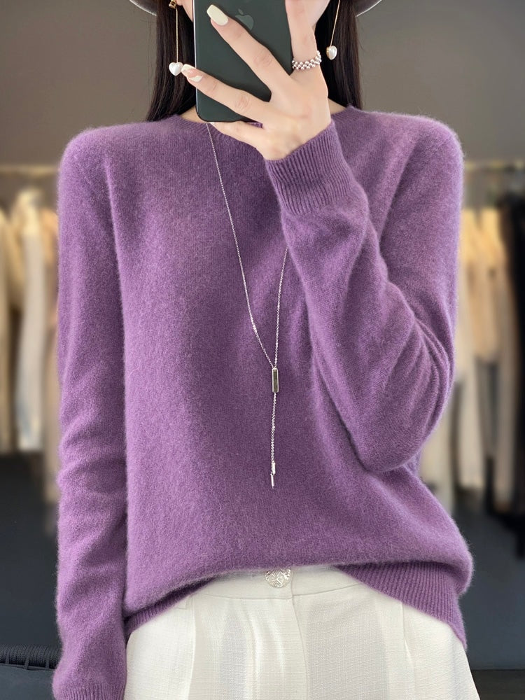 Purple crew neck sweater featuring a long pendant necklace, relaxed sleeves, and ribbed cuffs.