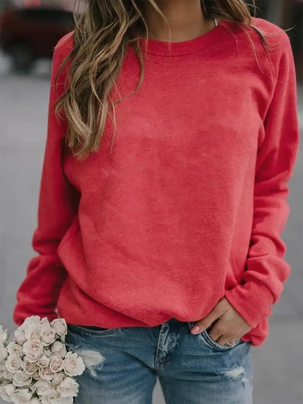 Coral red women's sweatshirt featuring a crew neckline, long raglan sleeves, and a ribbed hem.