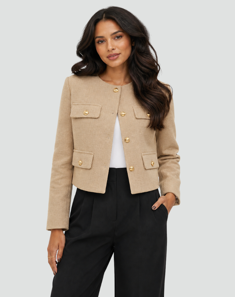 Front view of the light tan cropped blazer worn open over a white top, with gold-tone buttons and four flap pockets.