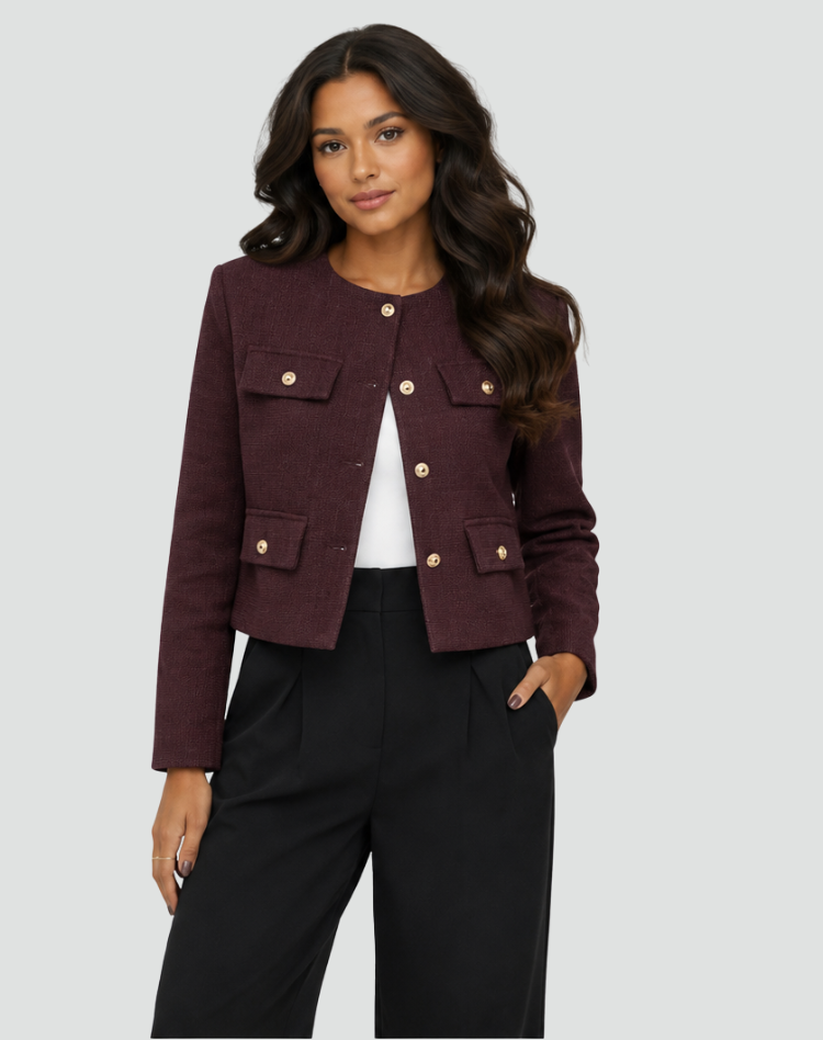 Front view of the burgundy cropped collarless blazer worn open, showing its long sleeves, gold-tone buttons, and flap pockets.