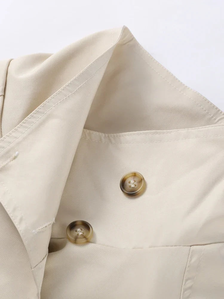 Close-up of the beige trench coat stand collar and overlapping double-breasted front with visible buttons.