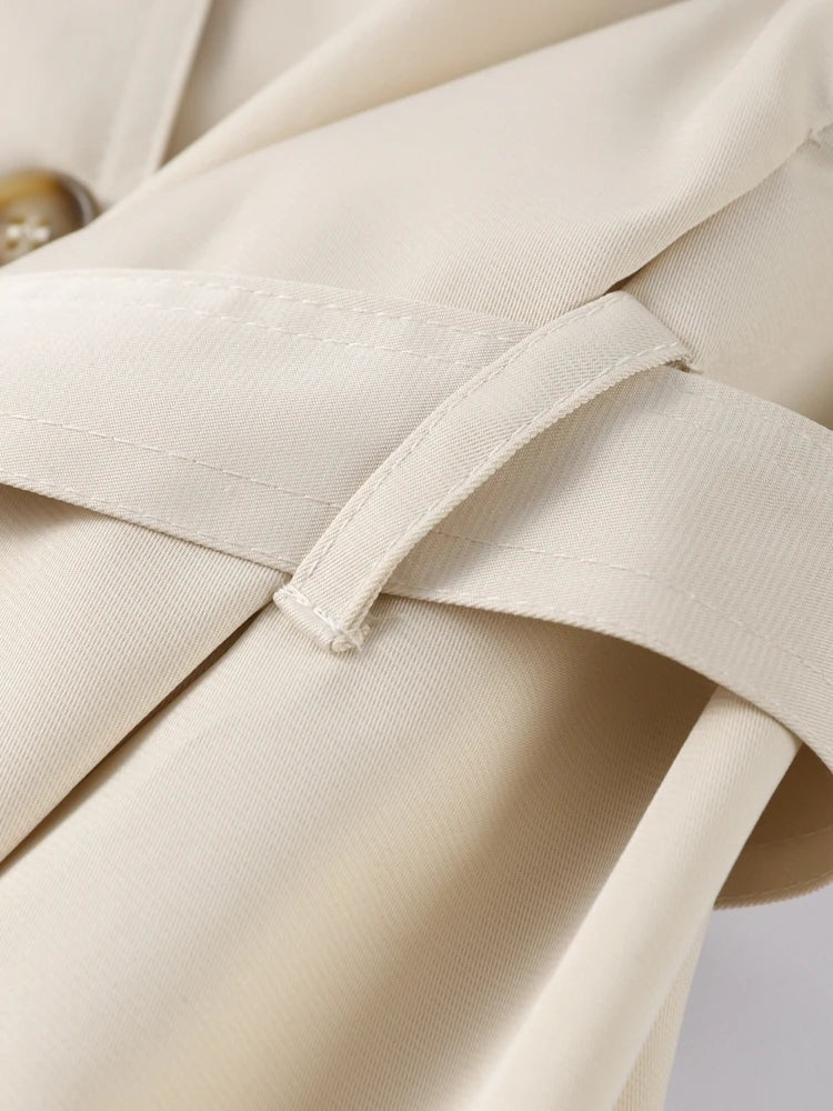Detail view of the trench coat cuff strap and stitched sleeve construction.