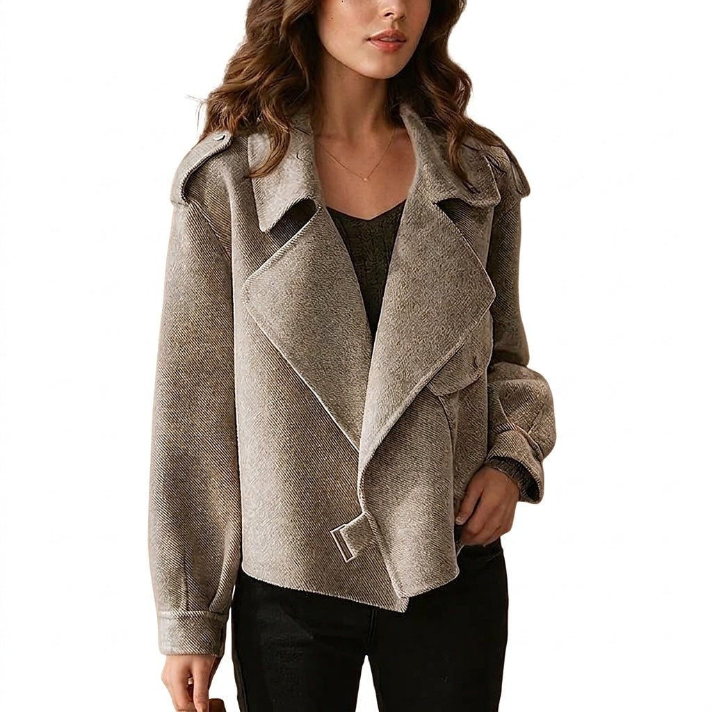 Cropped jacket shown from the front with wide overlapping lapels, long sleeves, shoulder epaulettes, buttoned cuffs, and a buckle at the asymmetrical hem.