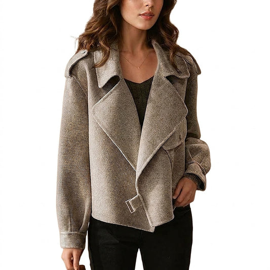 Cropped jacket shown from the front with wide overlapping lapels, long sleeves, shoulder epaulettes, buttoned cuffs, and a buckle at the asymmetrical hem.