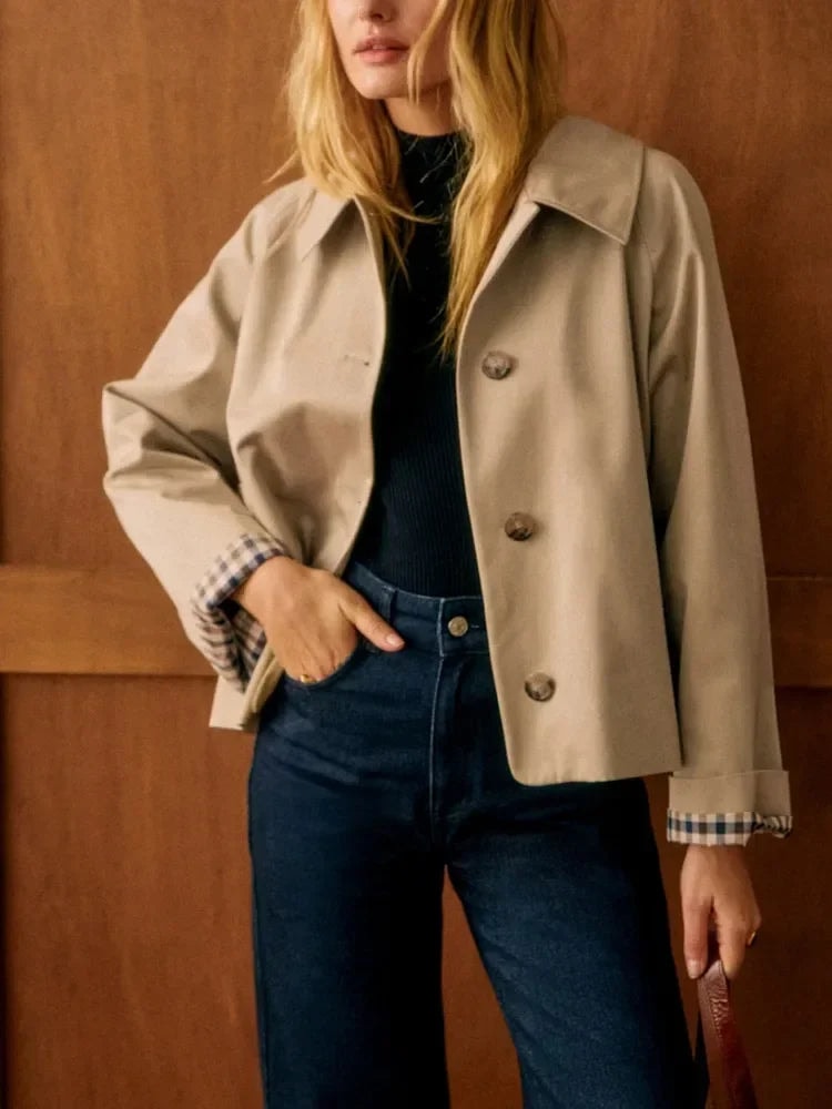 Front view of the cropped beige jacket showing its relaxed fit, pointed collar, and check cuffs.