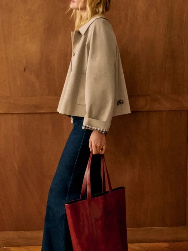 Side view showing the jacket’s cropped hem, relaxed shape, long sleeve, and checked cuff detail.