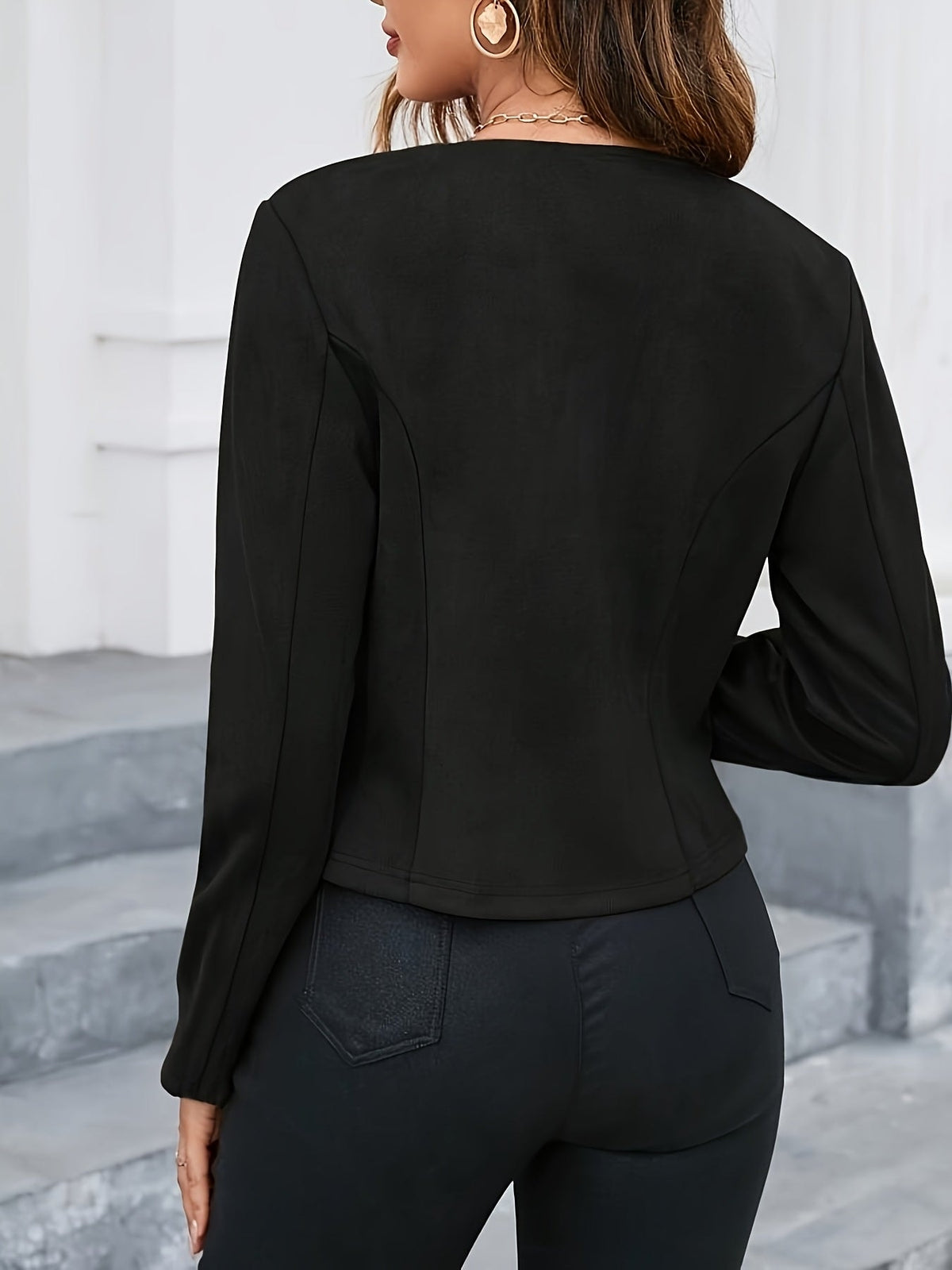 Back view of a black cropped jacket displaying its fitted cut and curved back seams.