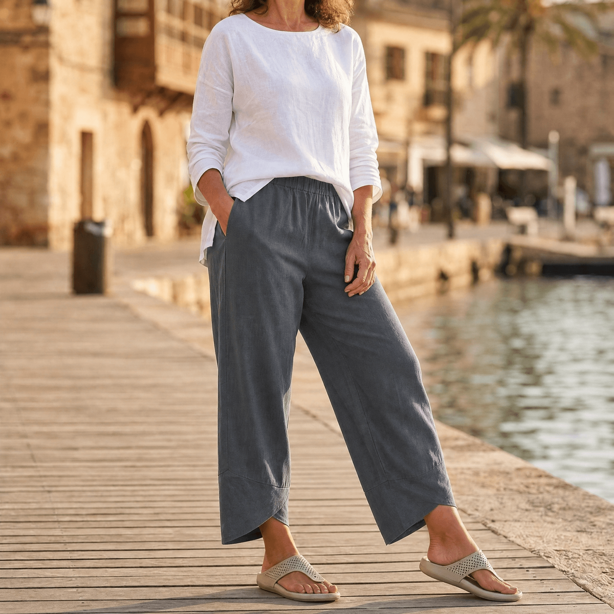 Front three-quarter view of gray cropped wide-leg pants showing the relaxed legs and asymmetric hems.