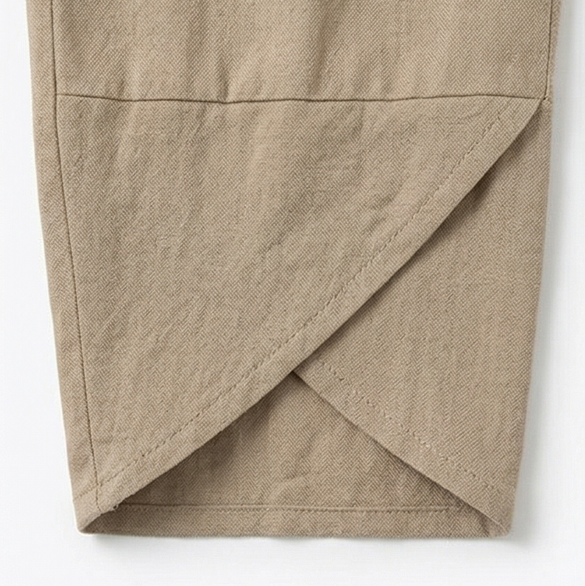 Detailed close-up of the pants' layered asymmetric crossover hem with visible stitching.