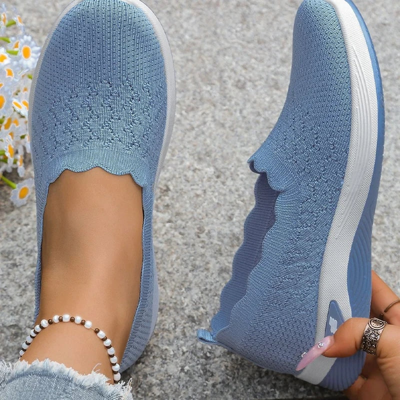 Blue knit slip-on shoes shown from above and from the side, highlighting the scalloped toplines.