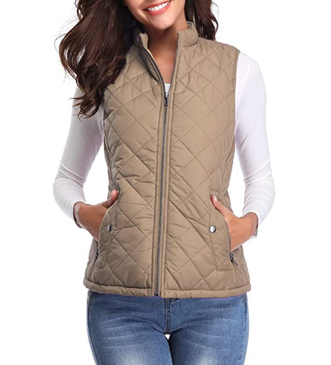 Tan hip-length quilted vest with a raised collar, full front zipper, and snap pocket closures.