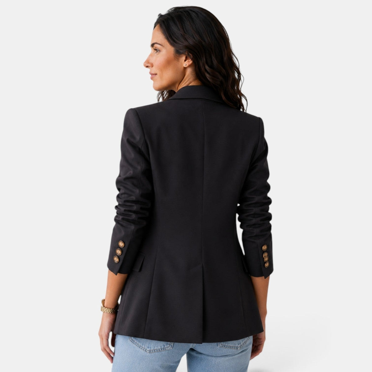 Back view of the black blazer showing its center seam, straight hem, fitted silhouette, and buttoned cuffs.