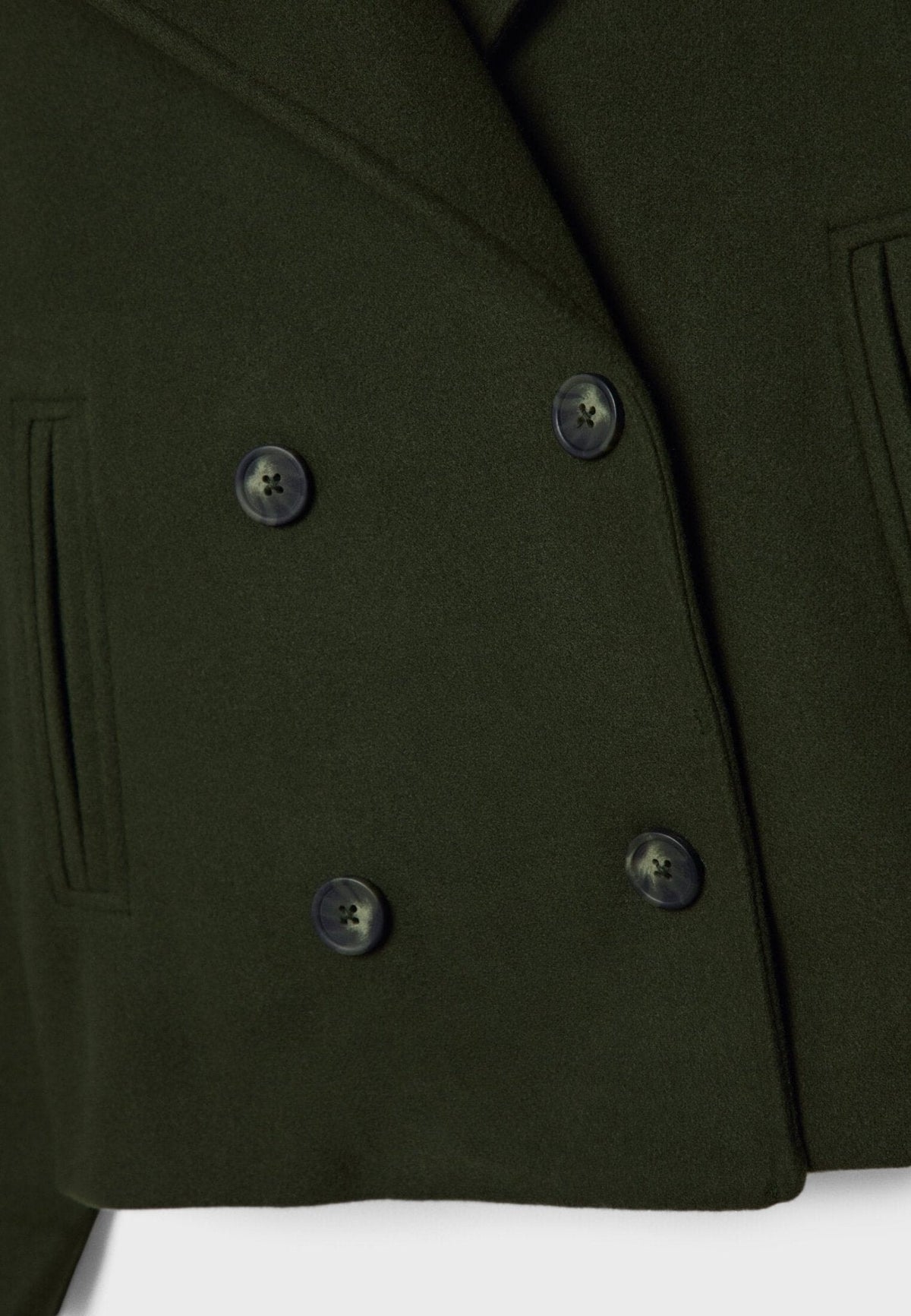 Close-up of the olive green jacket showing its four-button double-breasted front and slanted pocket detail.