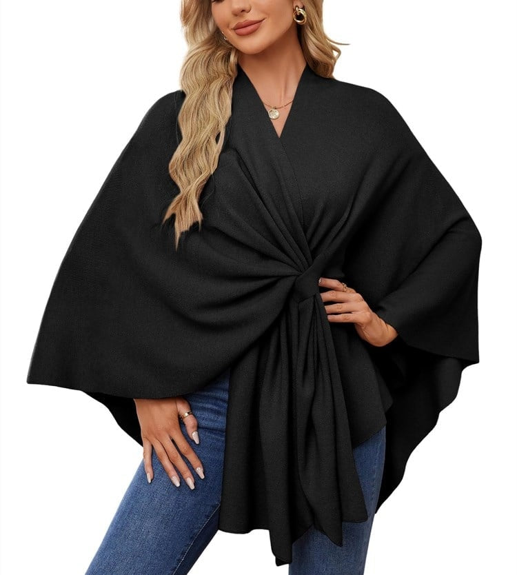 Black poncho wrap with a central tie-front closure, roomy sleeves, and cascading fabric.