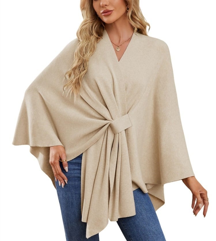 Sand-colored poncho wrap with a broad sleeve shape and neatly gathered front drape.