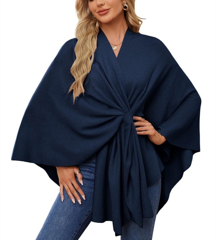 Deep navy poncho wrap featuring a gathered front tie, sweeping sleeves, and an uneven hem.