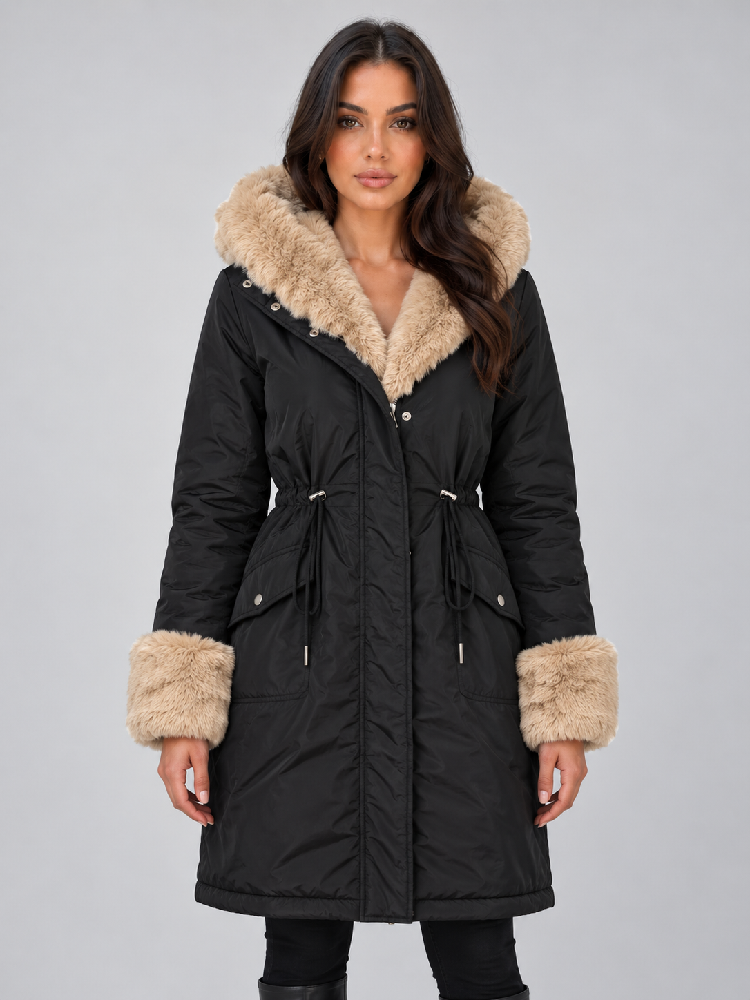 Front view of a black longline parka with a faux fur-trimmed hood and cuffs, drawstring waist, zip and snap front, and flap pockets.