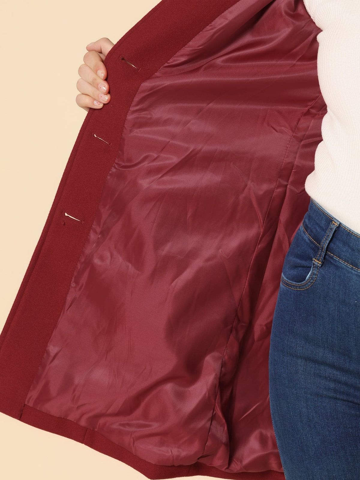 Close view of the burgundy coat opened to reveal its matching smooth lining and interior button plackets.