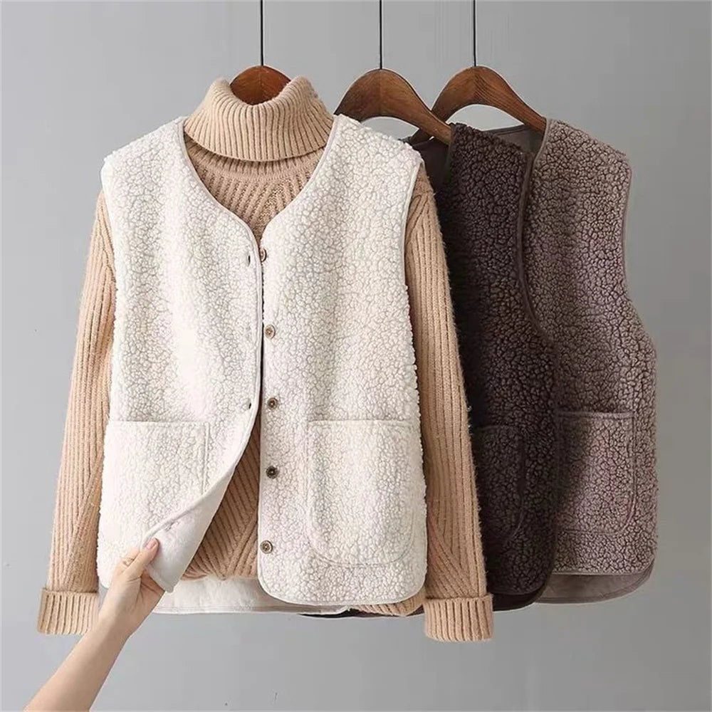 Cream fleece button-front layering vest shown over a tan ribbed turtleneck, with two patch pockets and a hand lifting the front edge.