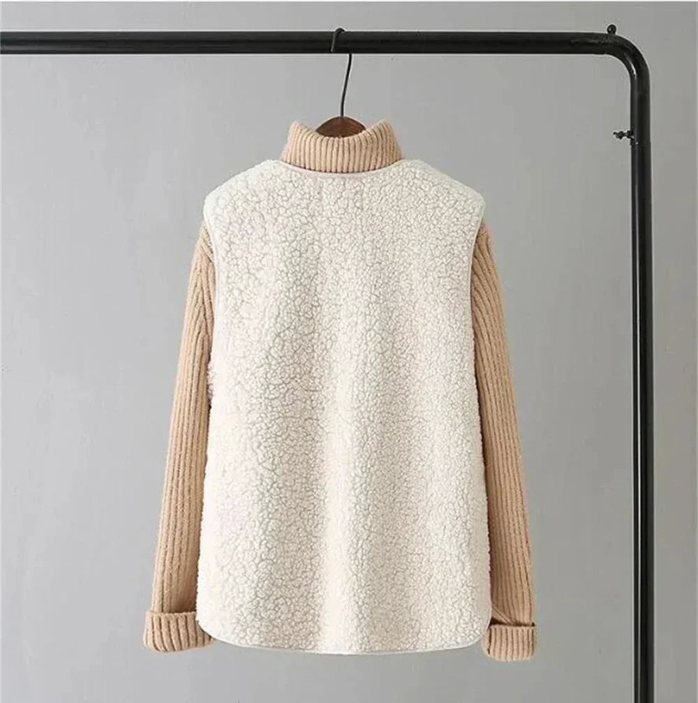 Rear view of the cream fleece vest layered over a tan sweater, showing the uninterrupted fleece back and hip-length rounded hem.