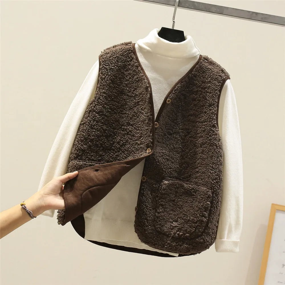 Dark brown fleece vest over a white turtleneck, with the open front panel lifted to show the darker inner side and two patch pockets.
