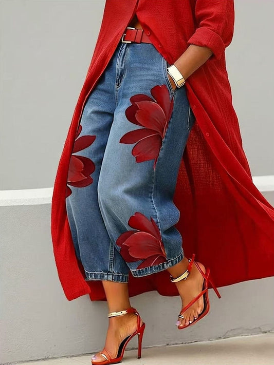 Cropped wide-leg blue jeans with oversized red floral prints, styled with a red longline shirt and strappy heels.