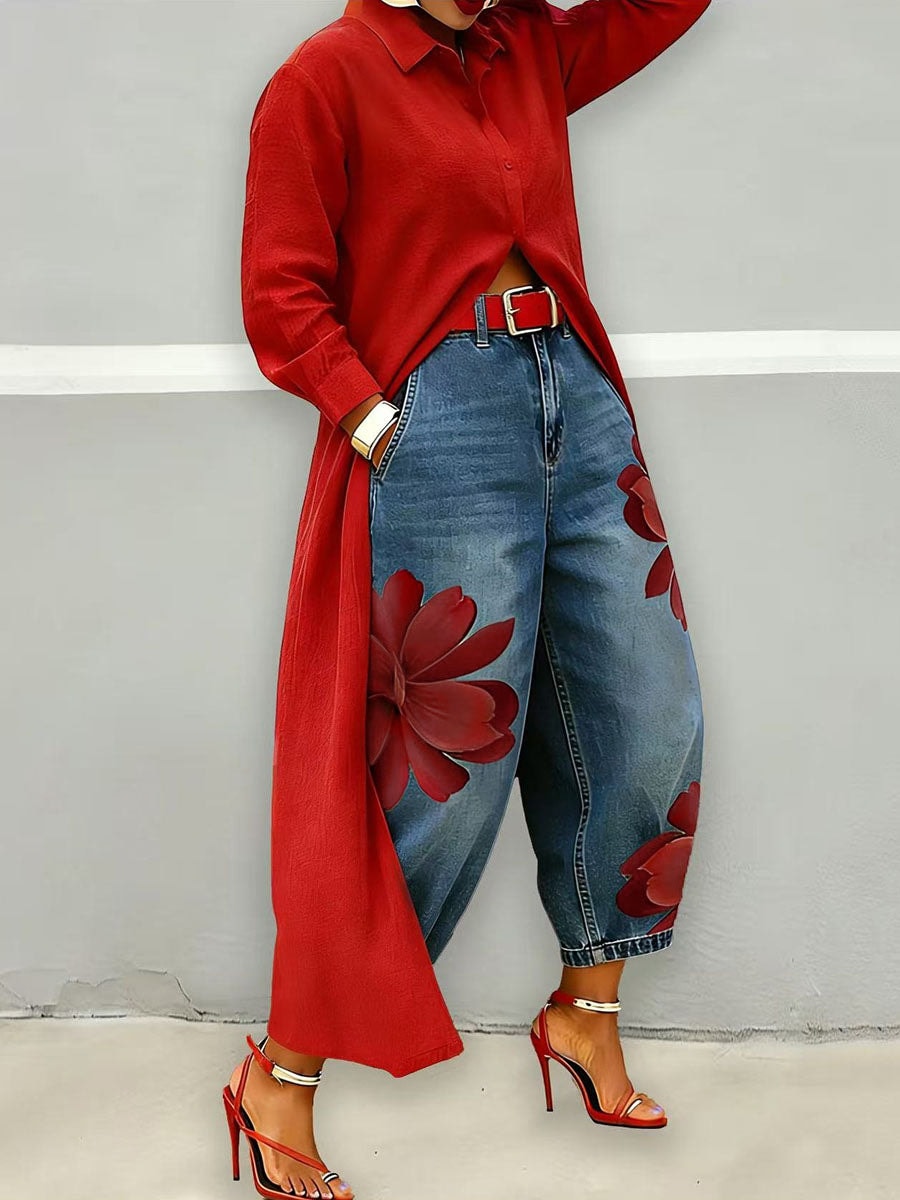 Side-angled view of blue cropped wide-leg jeans highlighting the large red flower print along the outer legs.