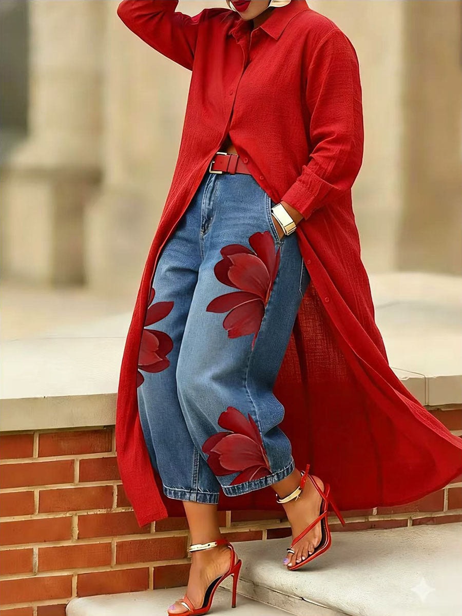 Cropped blue jeans with red floral artwork styled on steps, showing the relaxed wide-leg shape and ankle-skimming length.