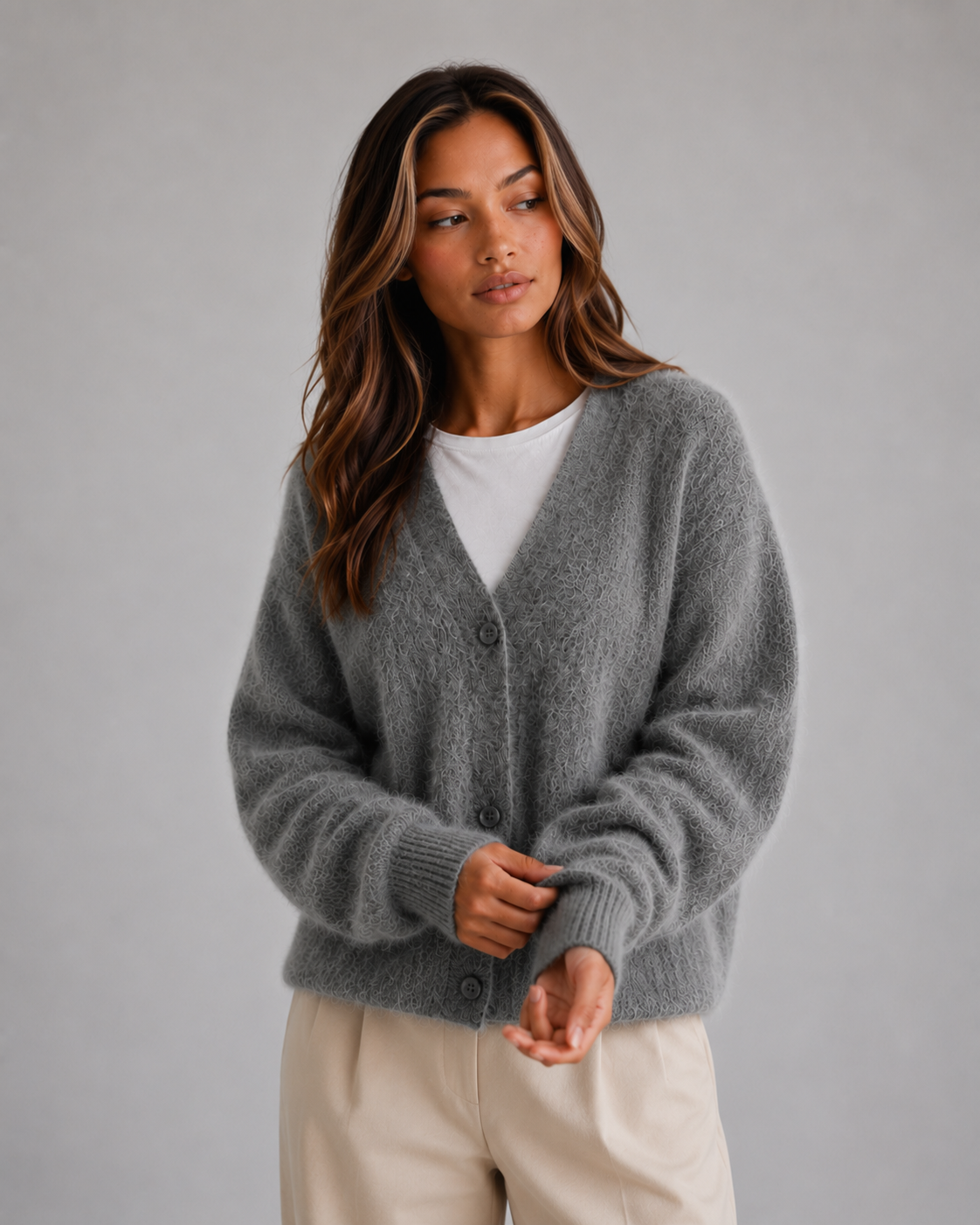 Front view of the cardigan in charcoal gray, layered over a white top with the V-neck and button closure visible.