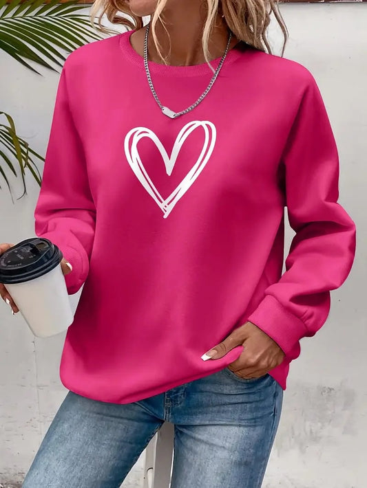 Bright pink crew neck sweatshirt with a white hand-drawn heart print, modeled with jeans and a takeaway cup.