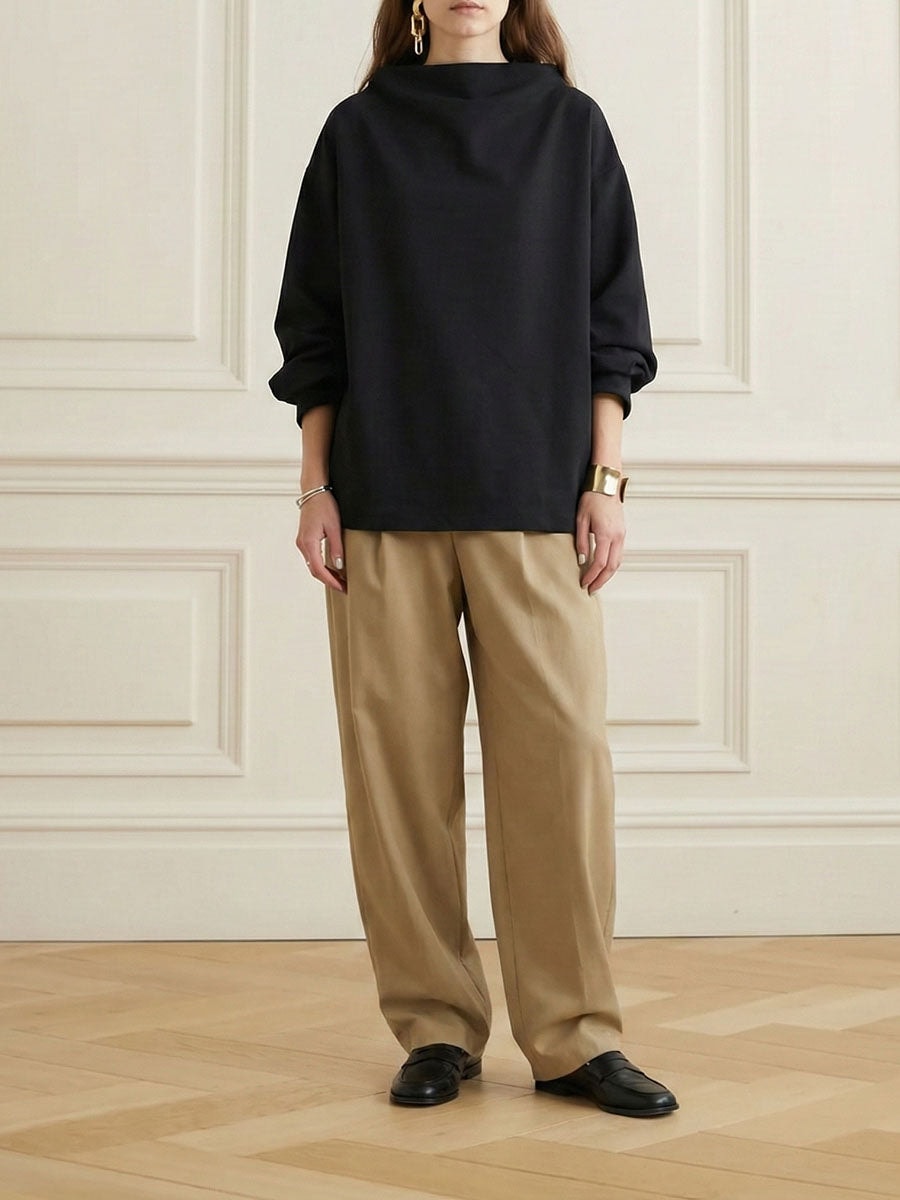 Full-length view showing the sweatshirt’s roomy silhouette and longer coverage styled with wide-leg trousers.