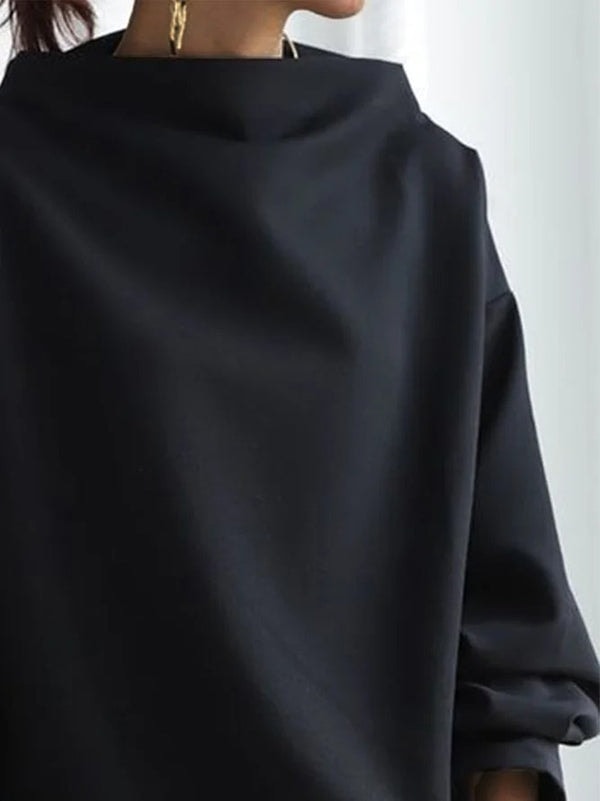 Upper-body close-up focusing on the structured high neckline and the broad shoulder line of the sweatshirt.