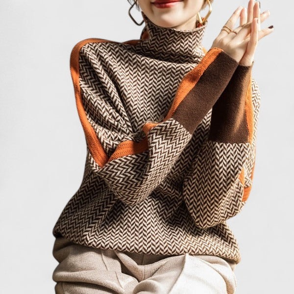 Front crop highlighting the sweater’s patterned body, high neck, long sleeves, and bold striped cuffs.