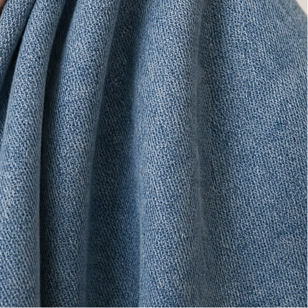 Close-up showing the blue fabric gathered into soft folds along the curved leg.