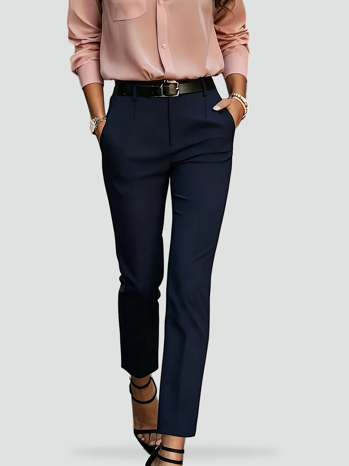 Full-length view of navy high-waisted slim-fit ankle trousers with slanted pockets and a front closure.
