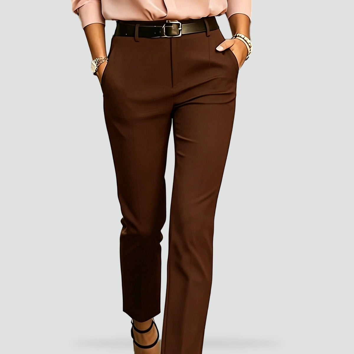 Close front view of dark brown trousers with a defined waist, front closure, and slim legs.